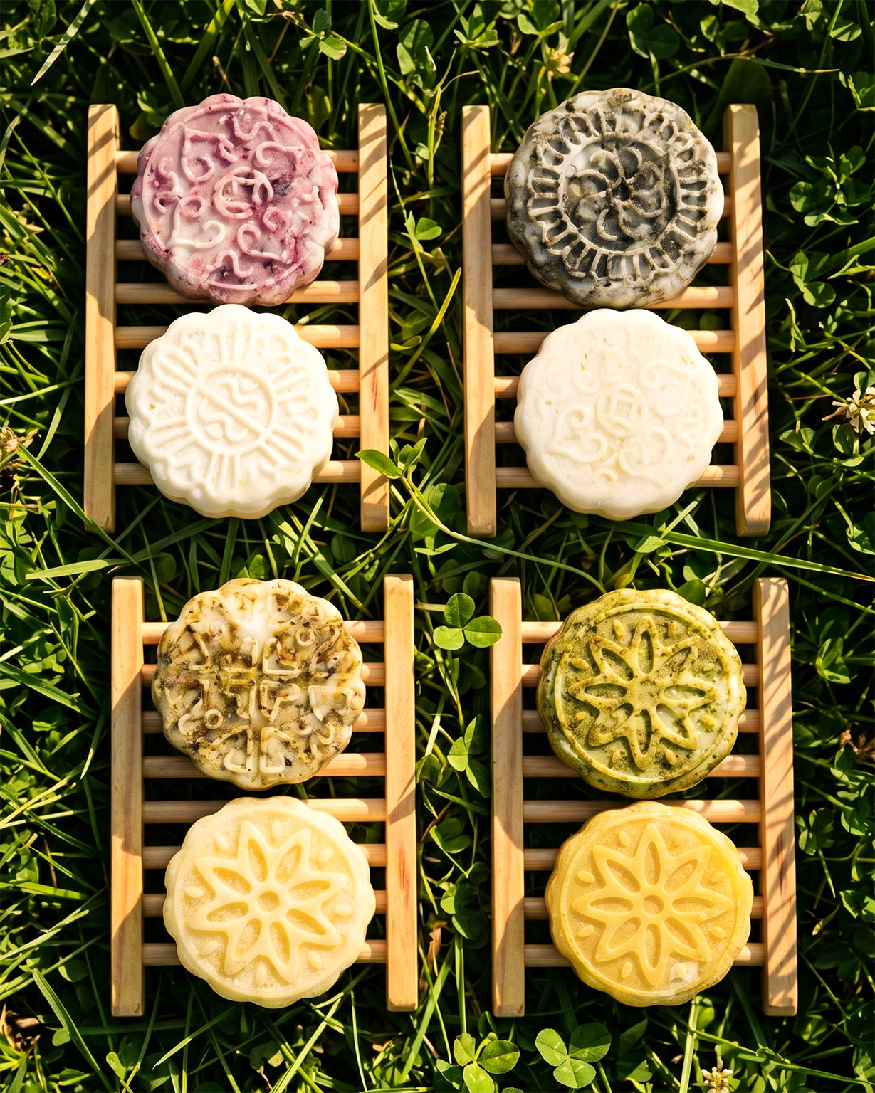 4 Sets of Provenciana Solid Hair Care Bars with drying caddy on top of grass, top-left to bottom-right: Neroli, Lavender, Ylang-Ylang, Ginger