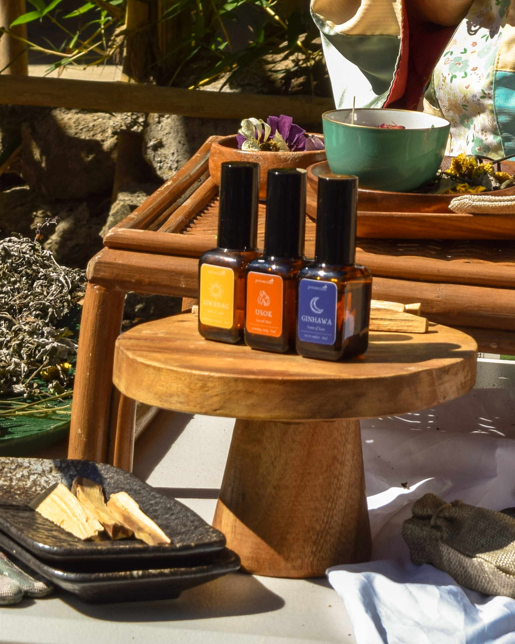Trio of 30ml Provenciana ritual mists (Liwanag, Usok, Ginhawa) displayed on a wooden stand with Palo Santo and dried herbs.
