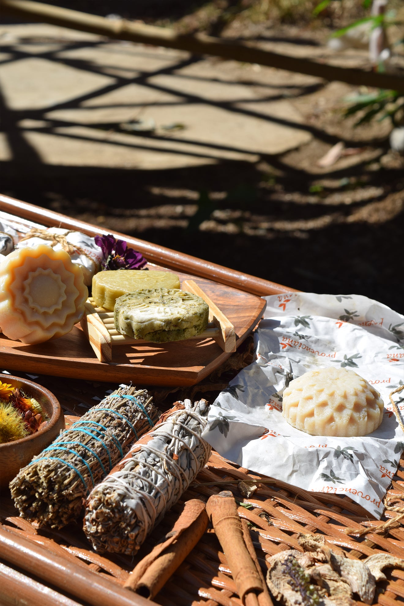Spices, herbs, and natural products on a wooden surface with a blurred outdoor background